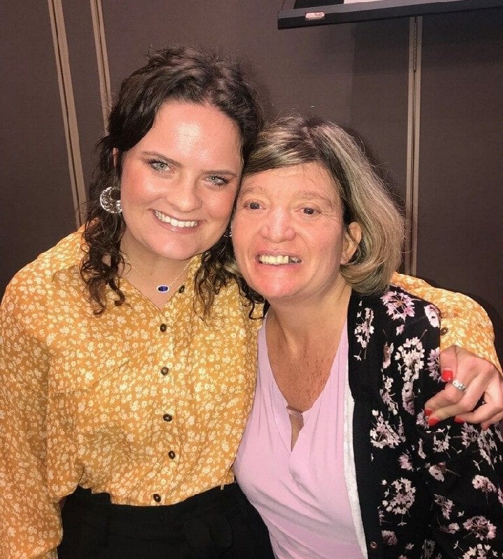 Two women smile at the camera.