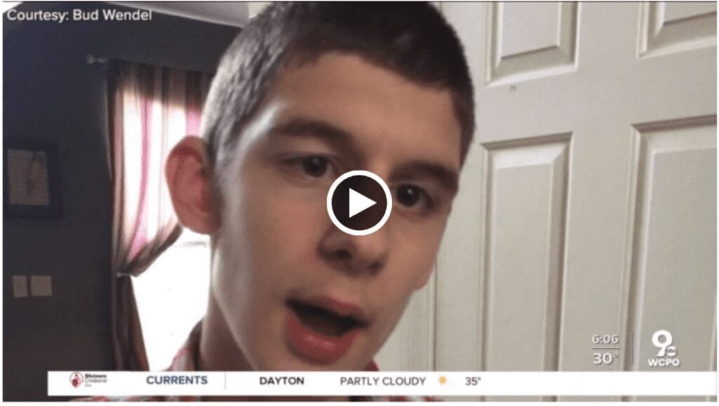 A teenage boy looks beyond the camera. A play button is in the center of the image. The WCPO 9 On Your Side logo is in the bottom of the image. 