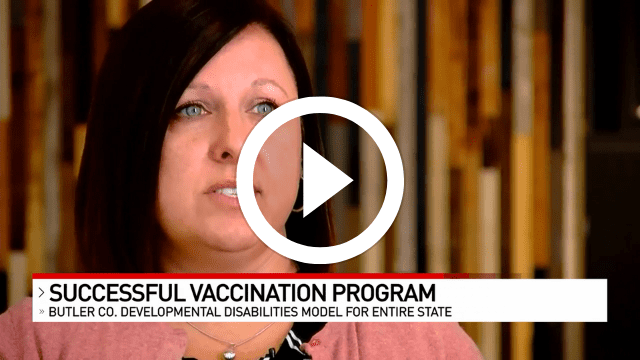 A woman looks at the camera. A banner below her name reads: Successful Vaccination Program