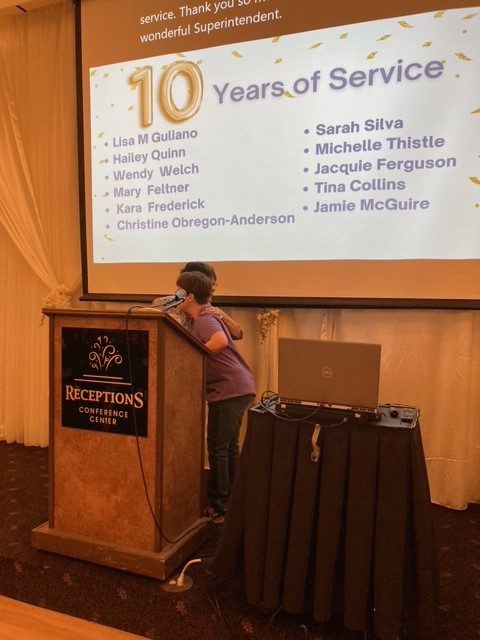 Courtney Hineman gives a 10 Year BCBDD Milestone Award to Lisa Guliano at Fairfield Receptions Banquet Center.