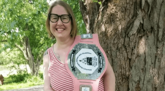 BCBDD SSA Kelly Studebaker posing by a tree with a Strongest Woman with Disabilities award