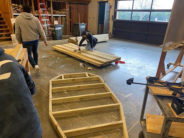 People building a wooden playset