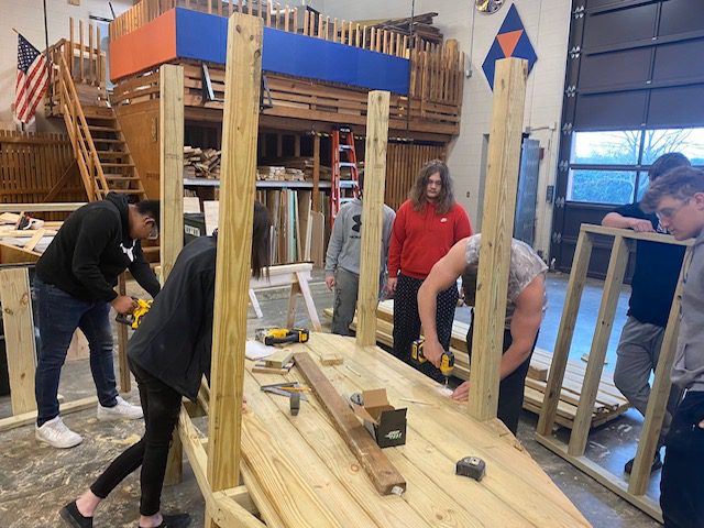 A group of people assembling a wooden playset