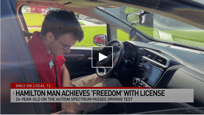 A man in the driver's seat puts on his seatbelt. Text on the picture reads: Only on Local12: Hamilton Man Achieves Freedom with License; 26-year-old on the Autism Spectrum passes driving test