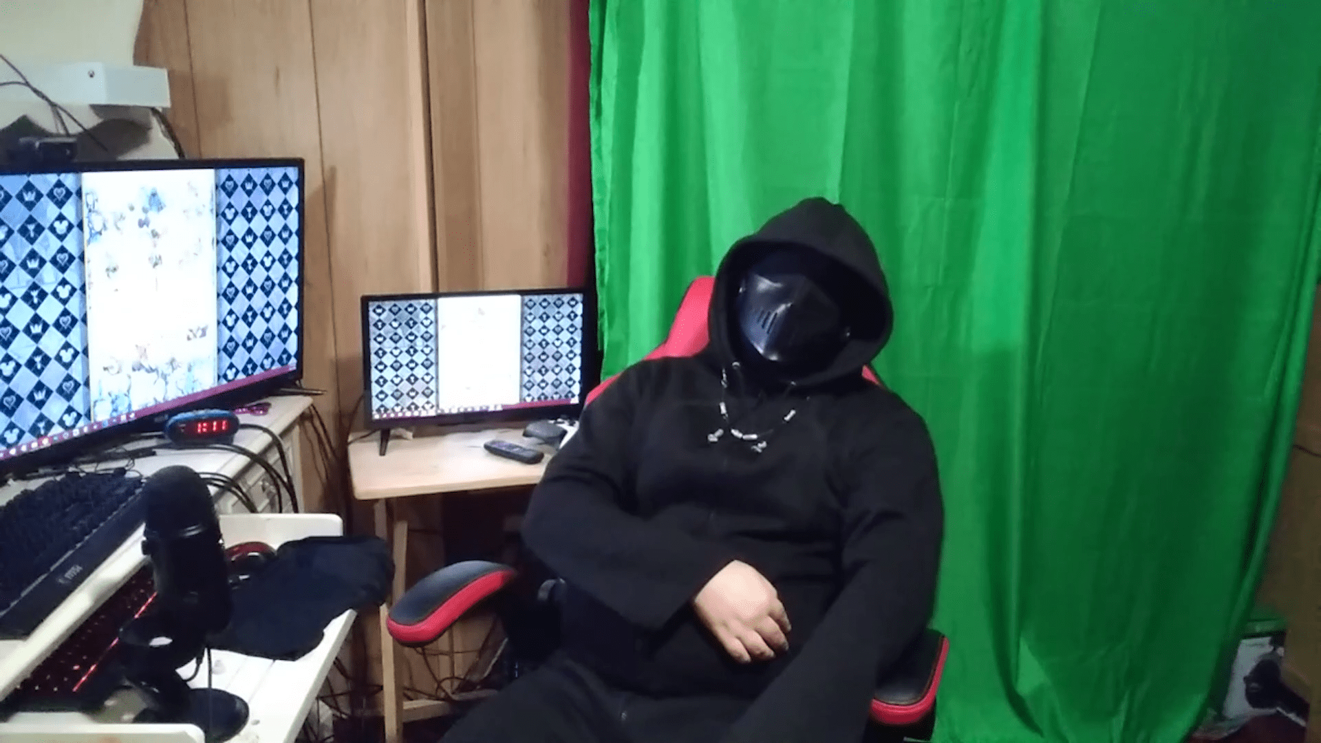 A man in a darth vader costume by a computer
