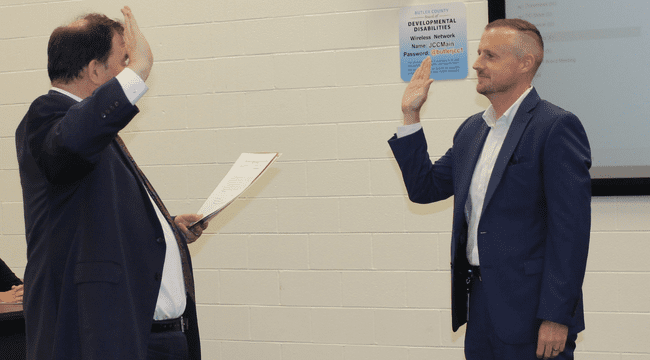 Dan Hughes being sworn in by a judge as a new board member