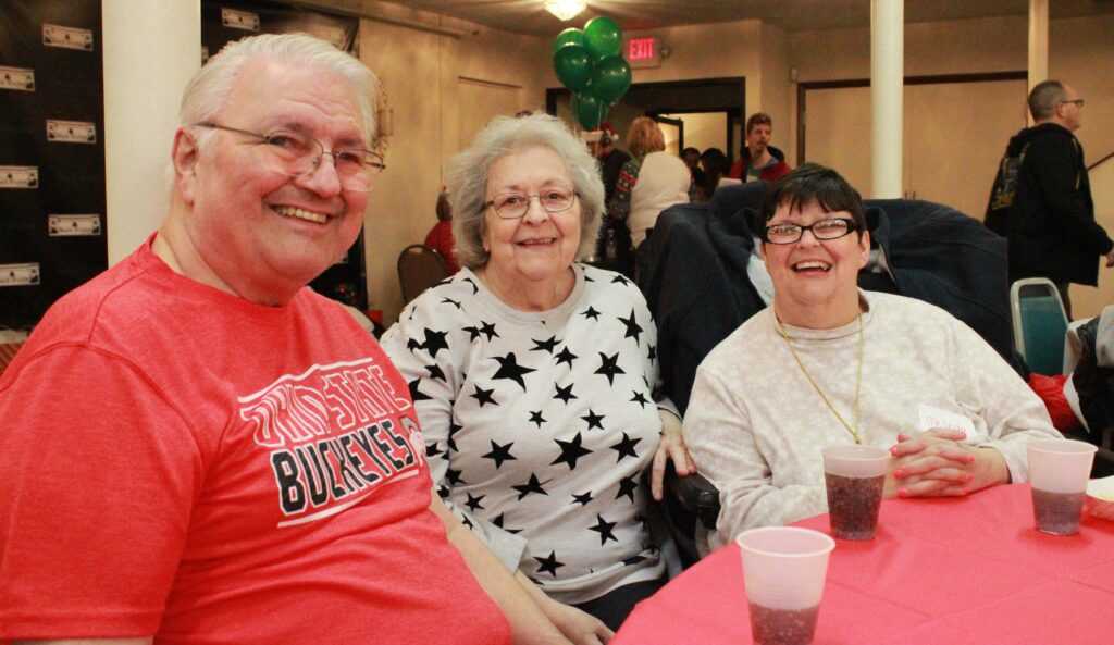 a family sitting next to eachother smiling at a table