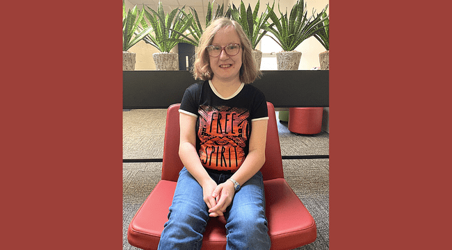 A woman sitting in a chair indoors smiling