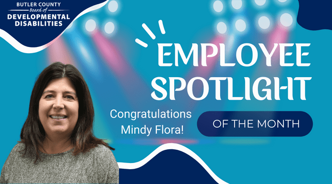 A graphic with a spotlight and a woman with text that reads, "Employee Spotlight of the month, Congratulations, Mindy Flora!"