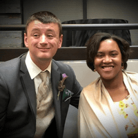 A man with his arm around a woman indoors