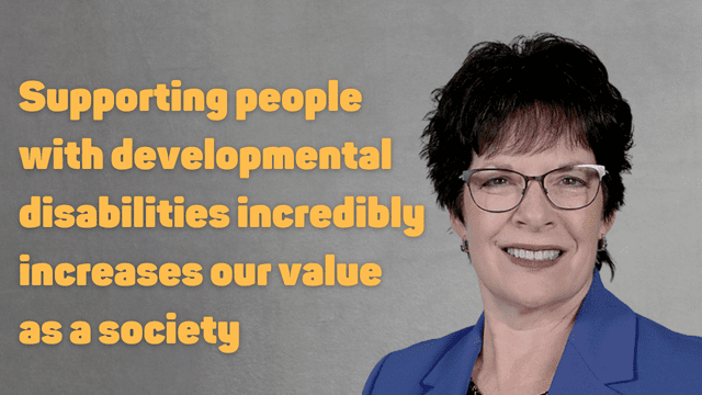 Headshot of a smiling woman in a blue blazer with text beside her that reads: Supporting people with developmental disabilities increasingly increases our value as a society.