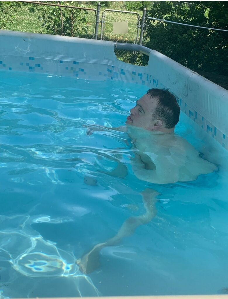 A man outdoors swimming in a pool.