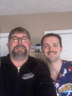 2 men indoors standing side by side smiling